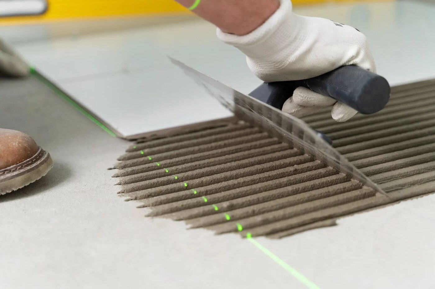 Fliesenverlegung mit Kammspachtel und Laserlinie